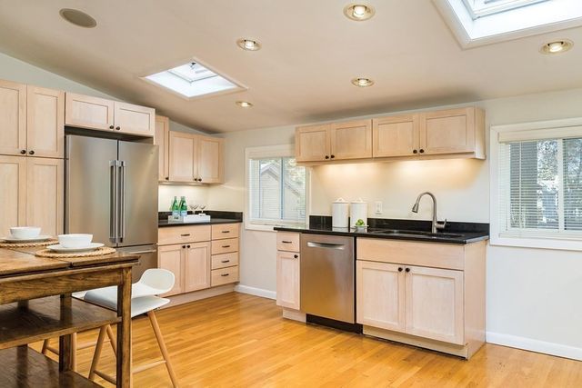 a kitchen with granite countertop a sink appliances cabinets and counter space