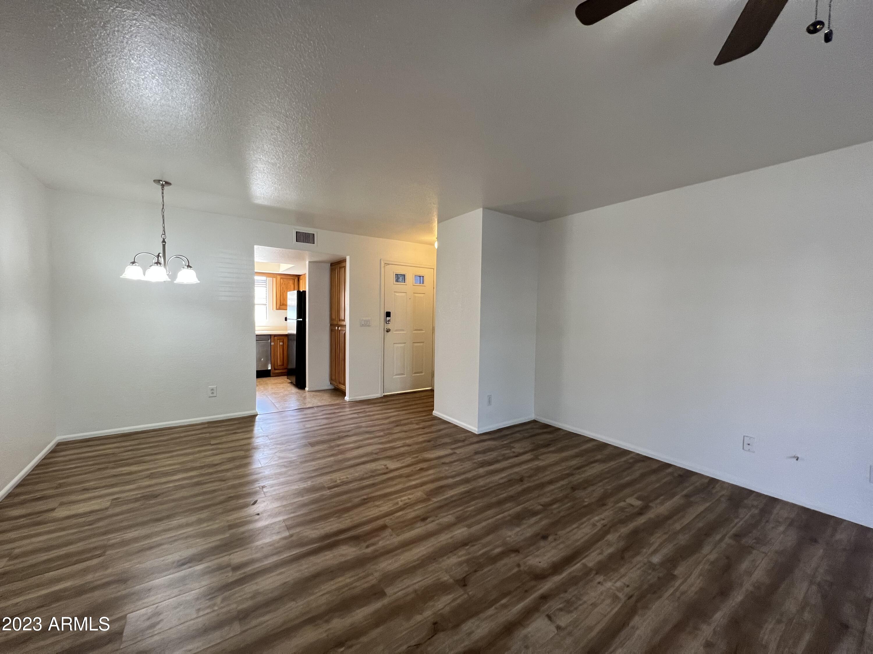 15402 North 28th Street, Unit 119 Phoenix, AZ 85032 - Photo 6 of 28 an empty room with wooden floor mirror and windows