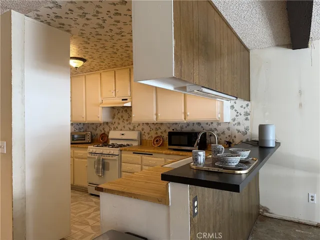 a kitchen with a sink a stove and cabinets