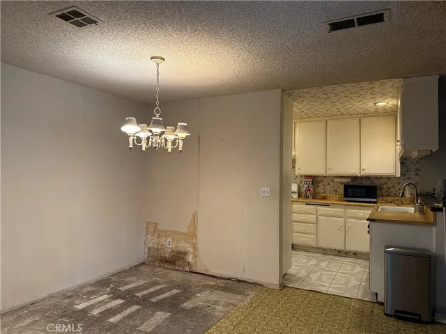a kitchen with a stove a refrigerator and chandelier