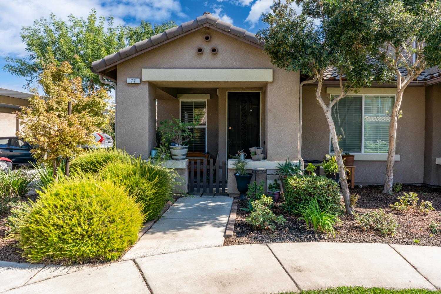 1116 West Walter Avenue, Unit 72 Fowler, CA 93625 - Photo 1 of 31 a front view of a house with a garden