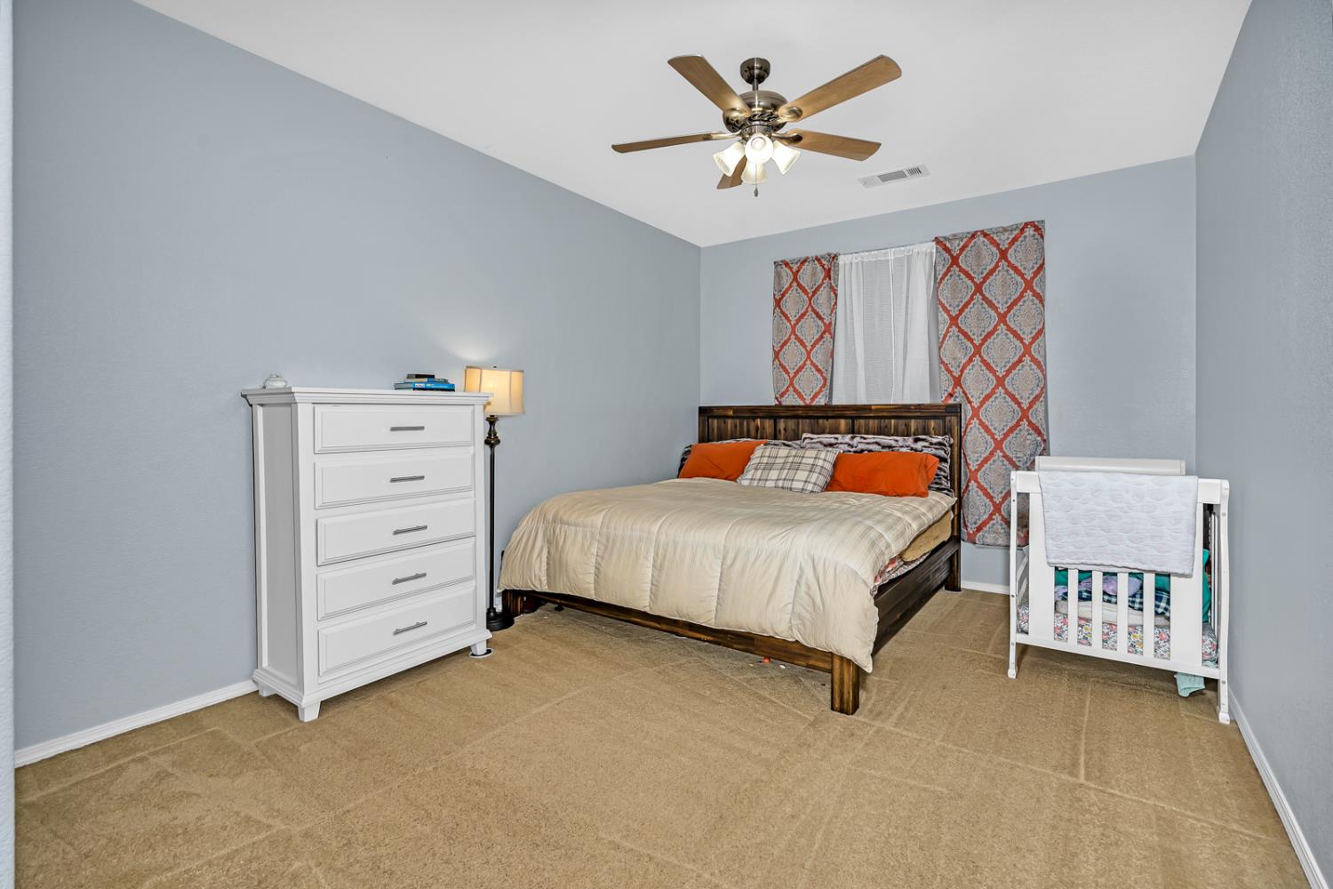1116 West Walter Avenue, Unit 72 Fowler, CA 93625 - Photo 14 of 31 a bedroom with a bed and a chandelier