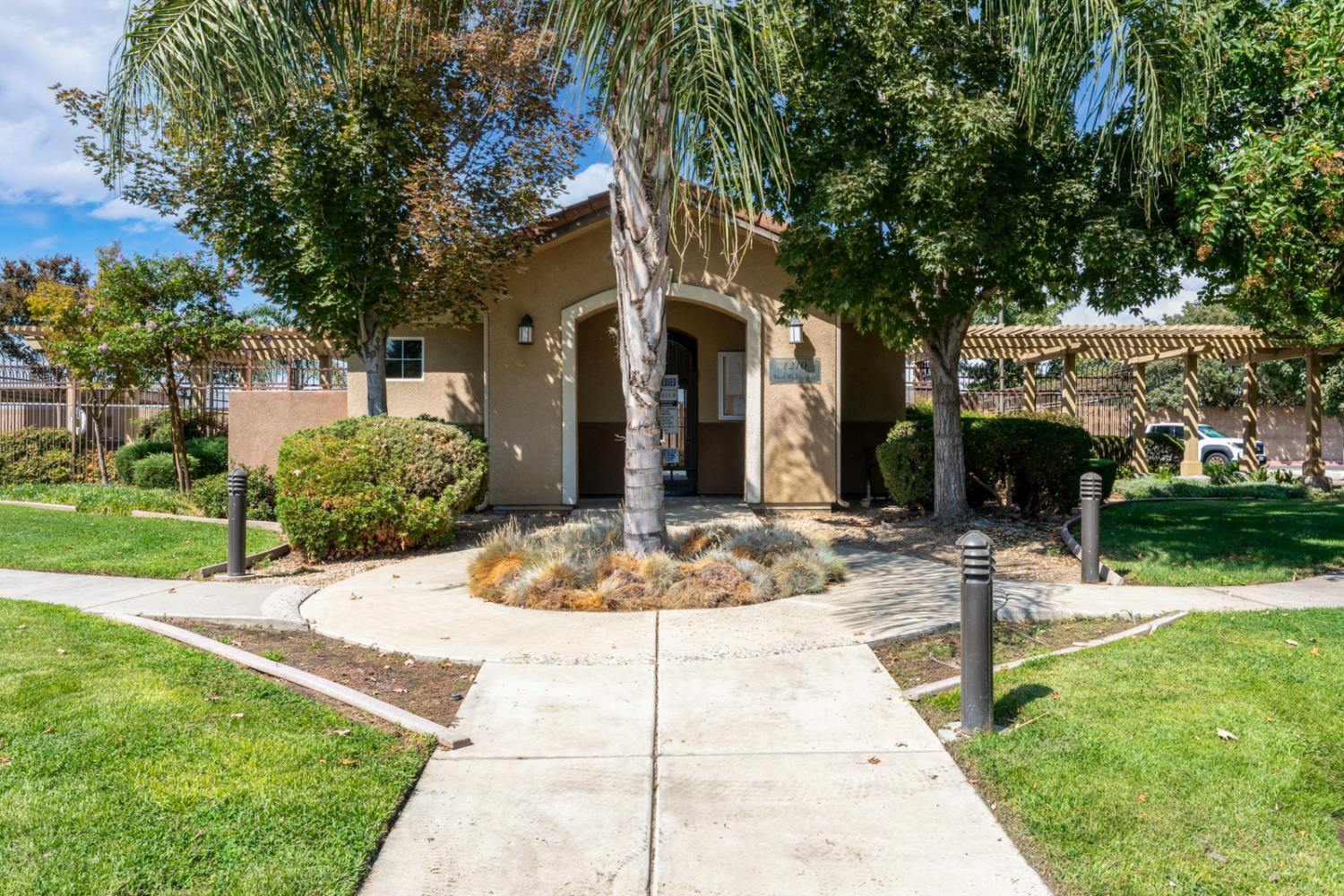 1116 West Walter Avenue, Unit 72 Fowler, CA 93625 - Photo 22 of 31 a view of a building with a yard and table and chairs under an umbrella