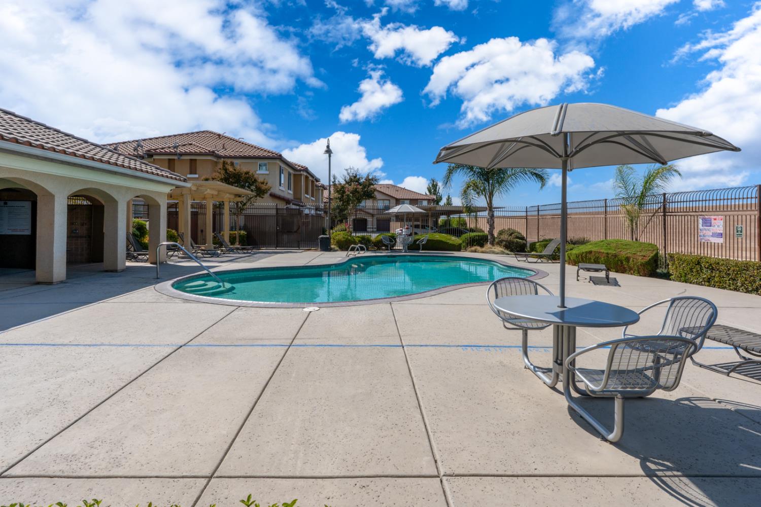 1116 West Walter Avenue, Unit 72 Fowler, CA 93625 - Photo 24 of 31 a view of a chairs and table under an umbrella