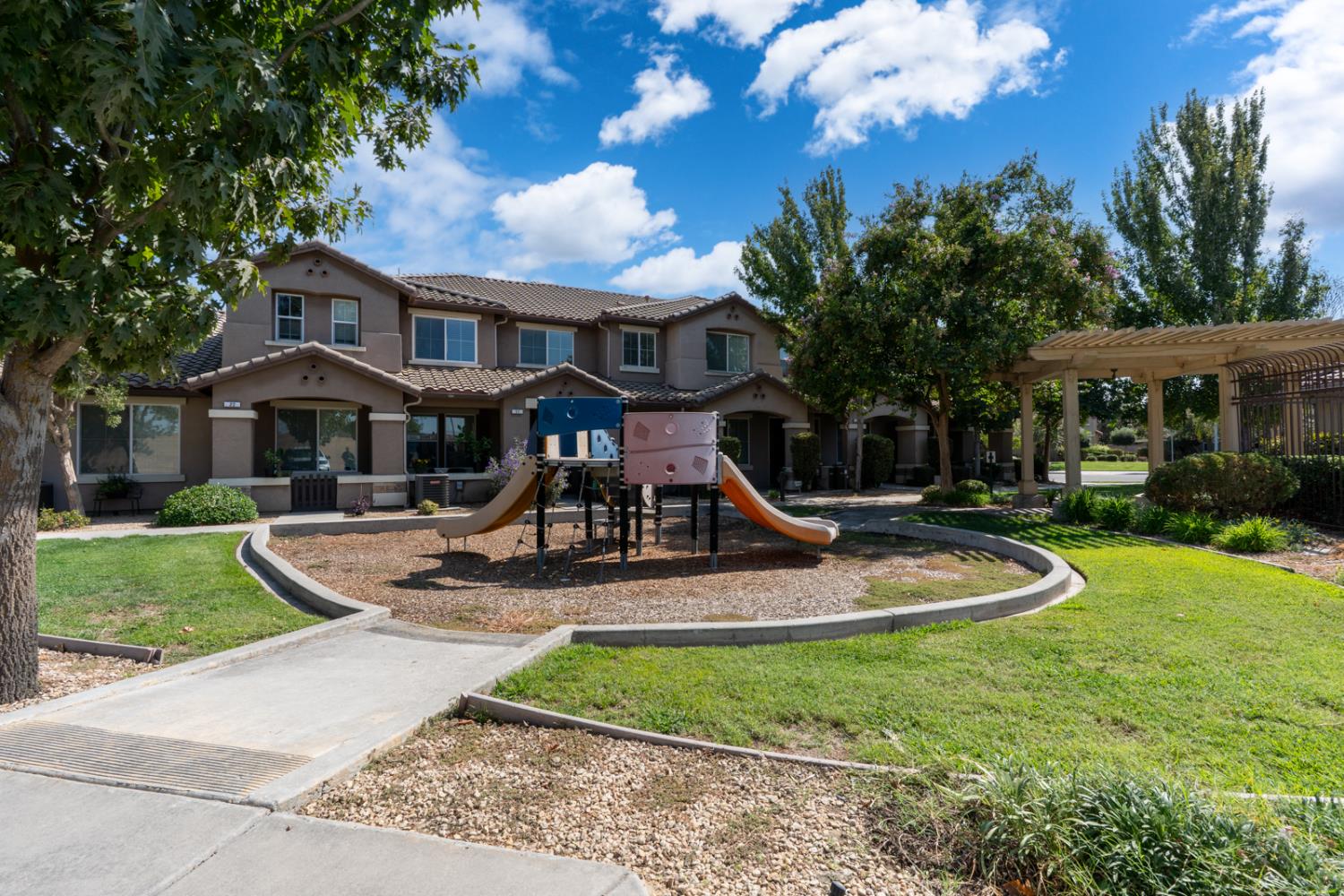 1116 West Walter Avenue, Unit 72 Fowler, CA 93625 - Photo 27 of 31 a front view of a house with garden and trees
