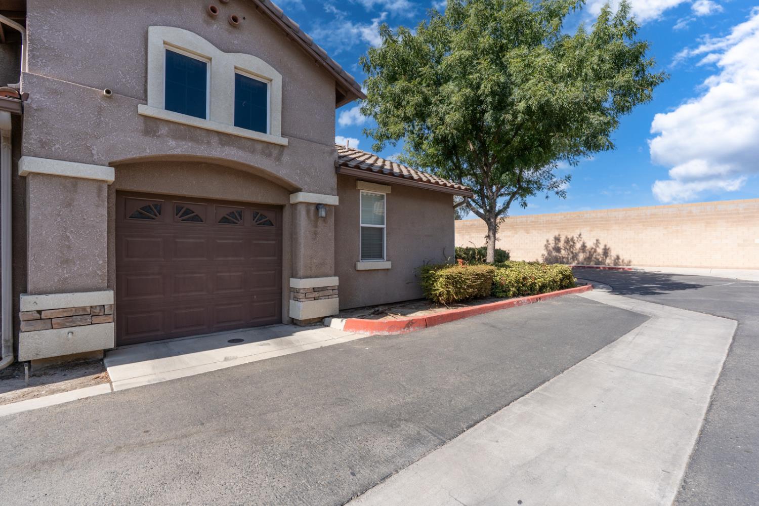 1116 West Walter Avenue, Unit 72 Fowler, CA 93625 - Photo 31 of 31 a front view of a house with a yard and garage