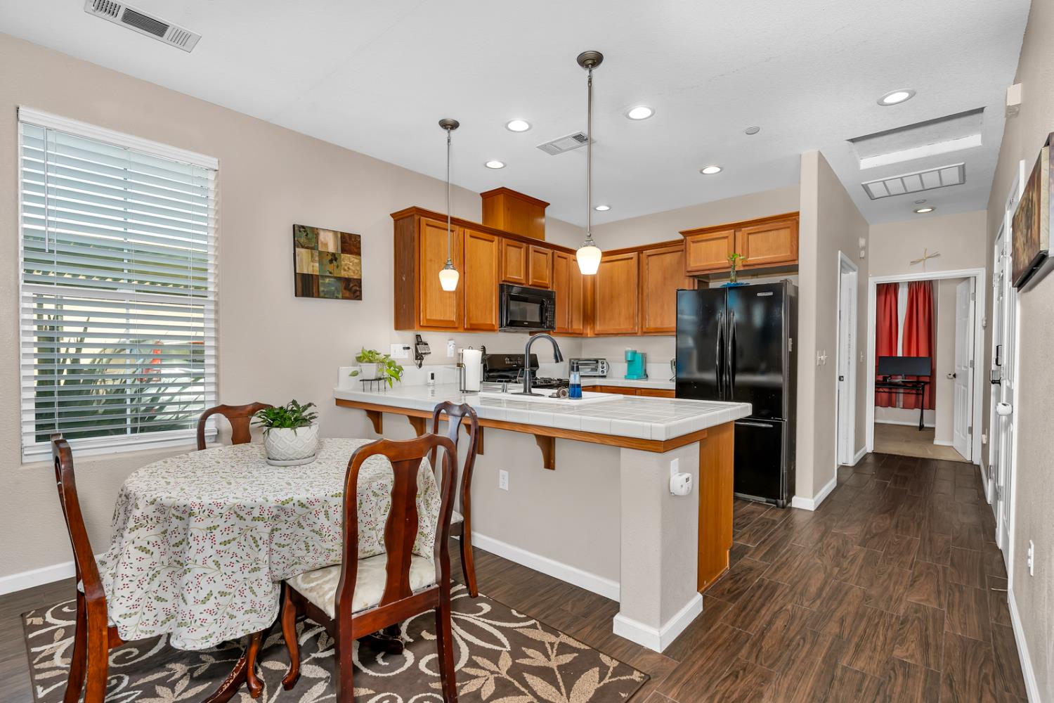 1116 West Walter Avenue, Unit 72 Fowler, CA 93625 - Photo 9 of 31 a kitchen with stainless steel appliances granite countertop a refrigerator a stove top oven a sink dishwasher and white cabinets with wooden floor