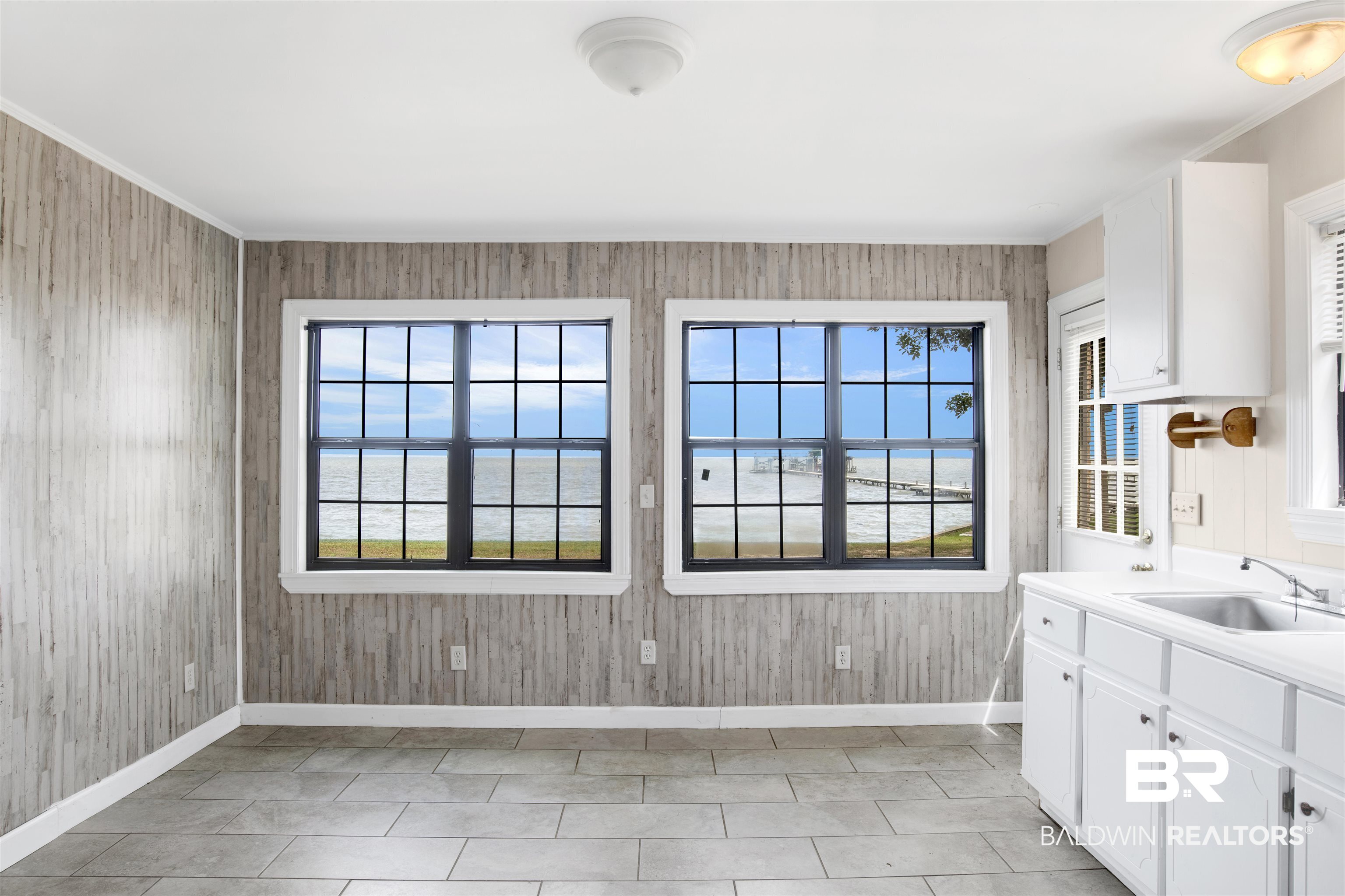 7411 Bay Road Mobile, AL 36605 - Photo 34 of 34 Kitchen featuring white cabinets, light countertops, a water view, light tile patterned flooring, and crown molding