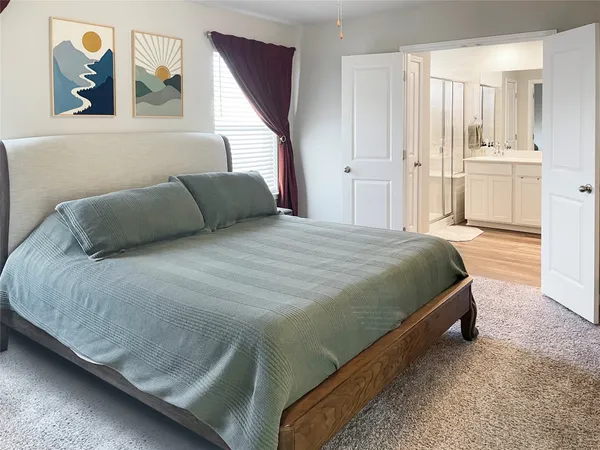 a bedroom with a bed and painting on the wall