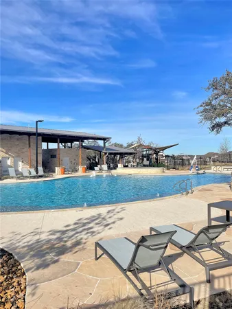a view of swimming pool with seating area and lake view
