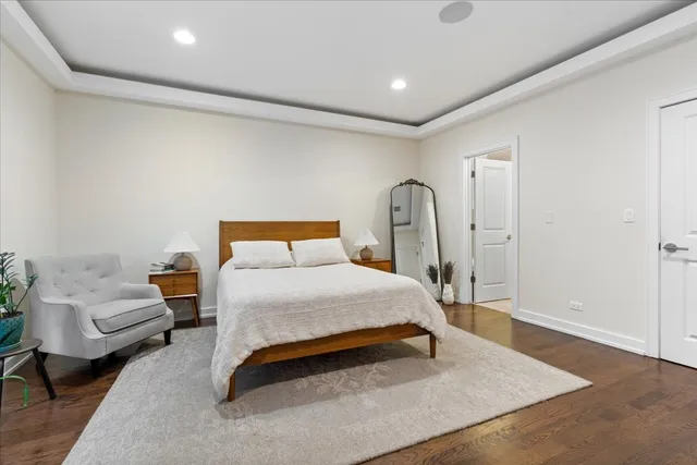 a bedroom with a bed wooden floor and couch