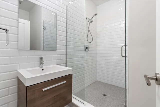 a bathroom with a shower sink and mirror
