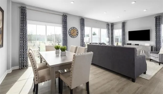 a living room with furniture a flat screen tv and a floor to ceiling window