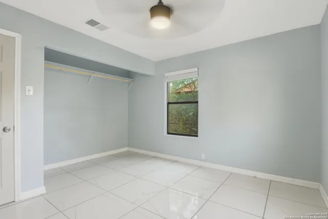 an empty room with windows and closet