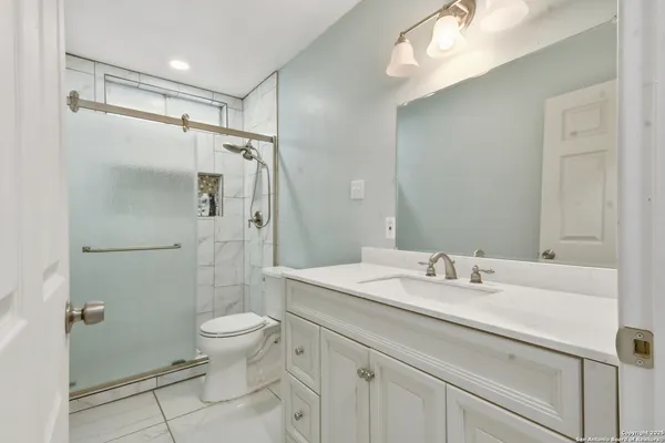 a bathroom with a sink toilet double vanity and shower