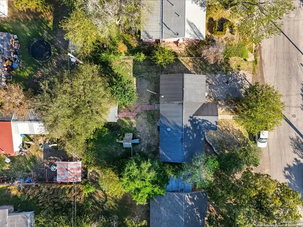 an aerial view of residential house with outdoor space and trees all around