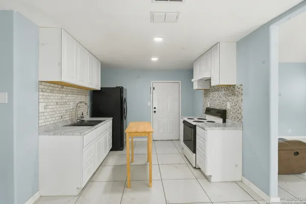 a kitchen with stainless steel appliances kitchen island granite countertop a sink and a refrigerator
