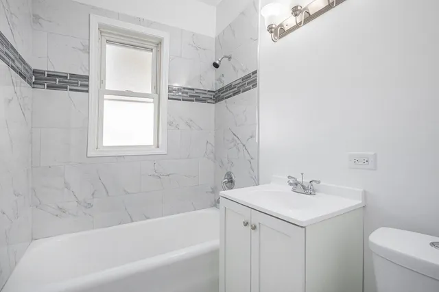 a bathroom with a sink mirror vanity and toilet