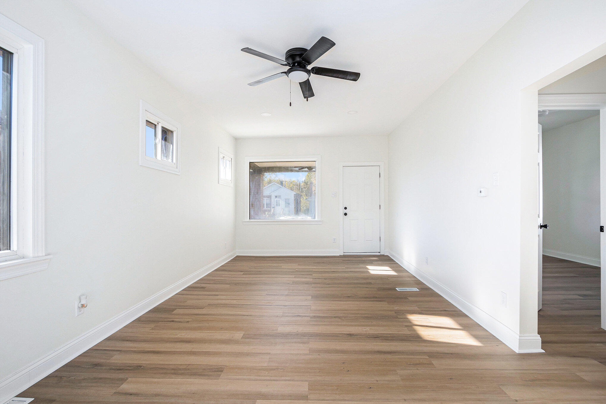 3625 Virginia Street Gary, IN 46409 - Photo 2 of 15 an empty room with wooden floor ceiling fan and windows