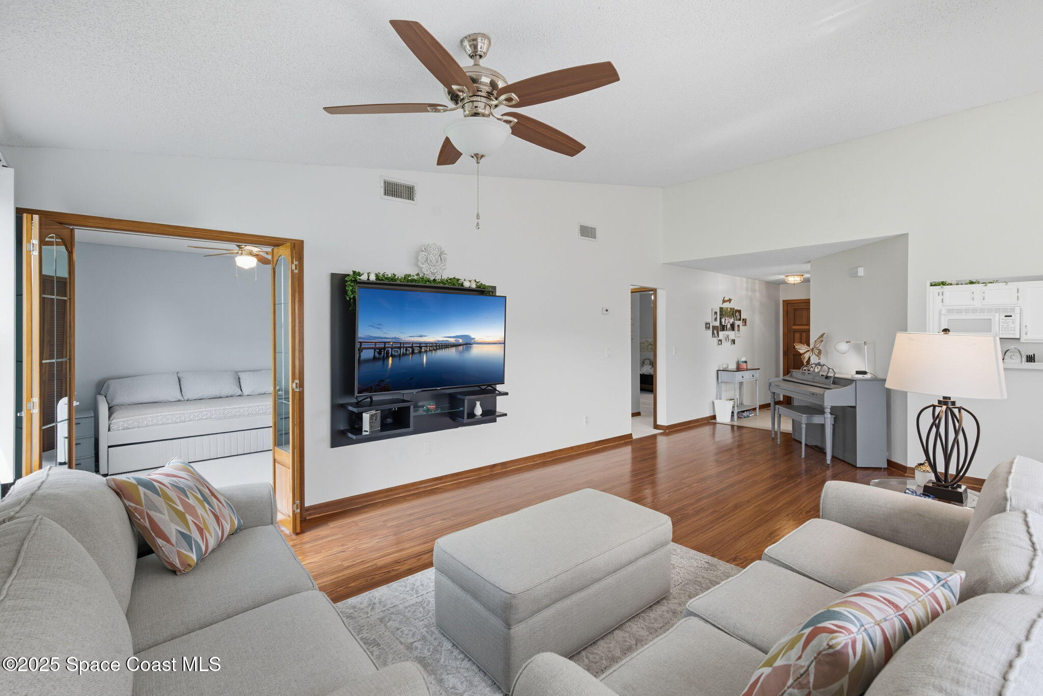 710 Spring Valley Drive Melbourne, FL 32940 - Photo 16 of 30 a living room with furniture and a flat screen tv with wooden floor