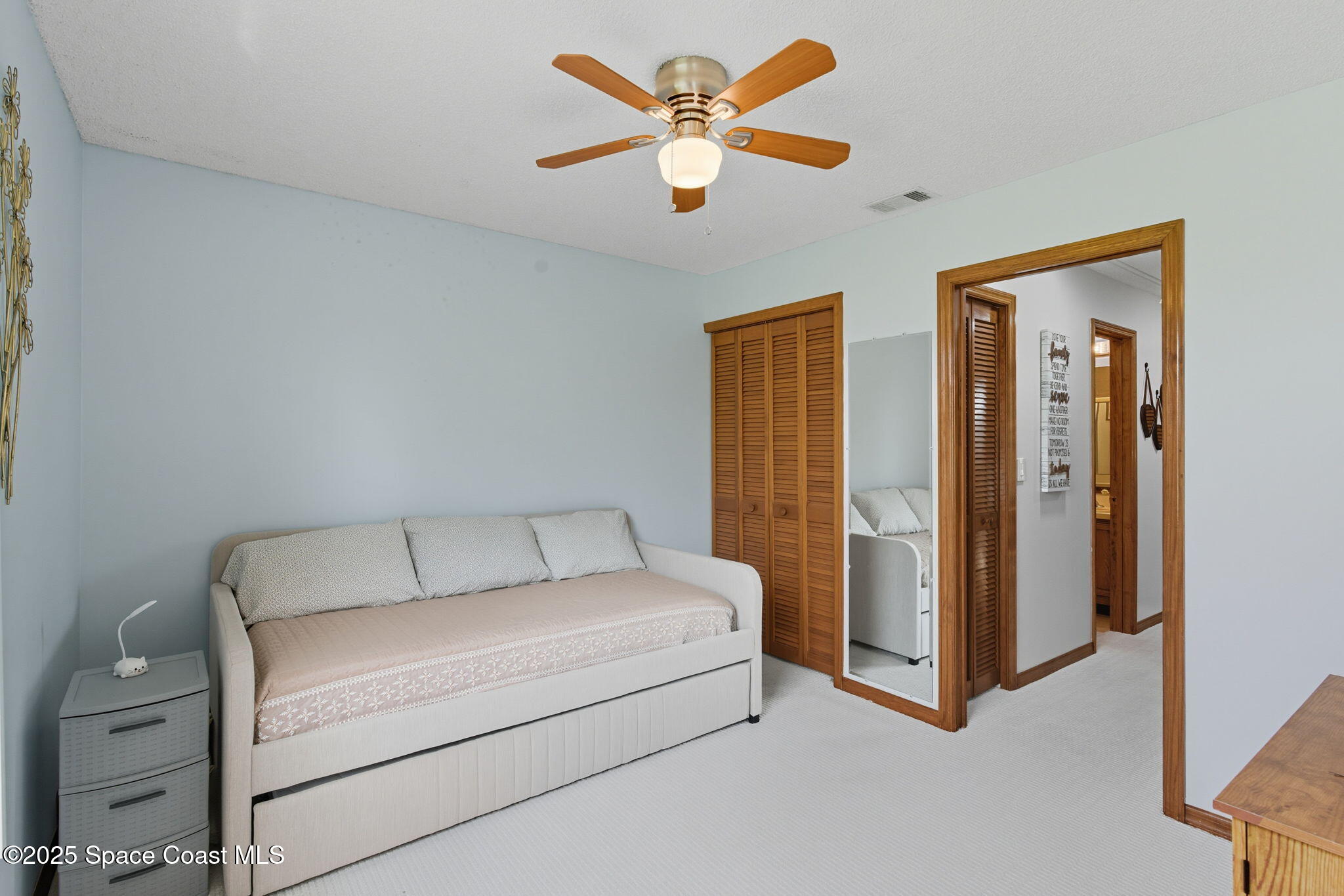 710 Spring Valley Drive Melbourne, FL 32940 - Photo 23 of 30 a bedroom with a bed and a ceiling fan