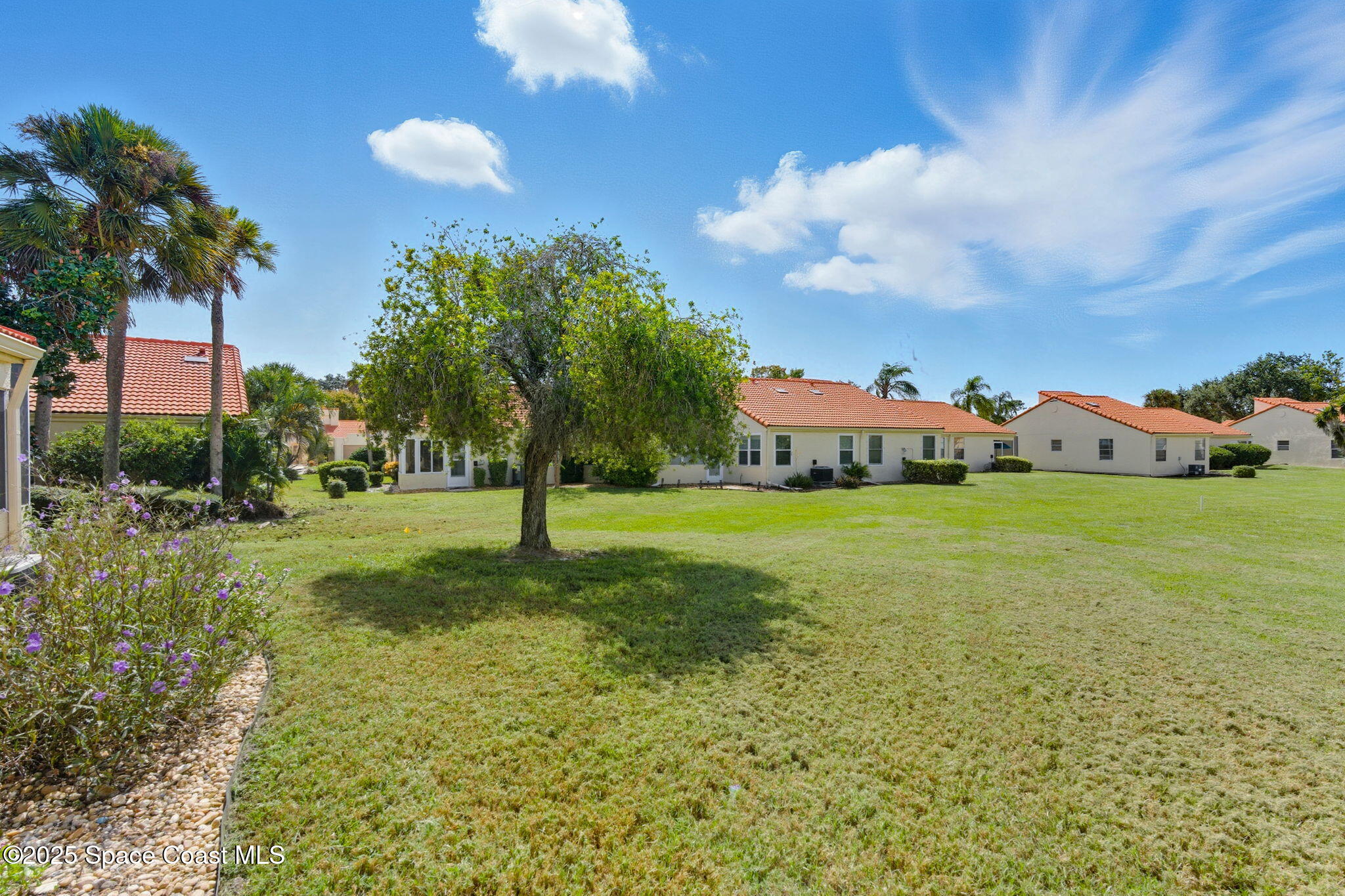 710 Spring Valley Drive Melbourne, FL 32940 - Photo 30 of 30 a view of a house with a big yard and palm trees