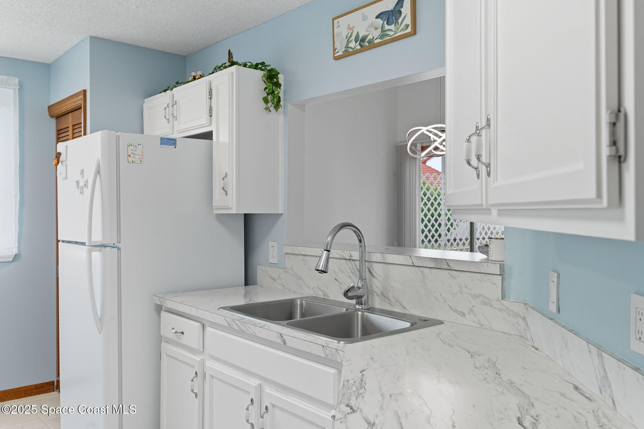 710 Spring Valley Drive Melbourne, FL 32940 - Photo 10 of 30 a white kitchen with refrigerator and sink