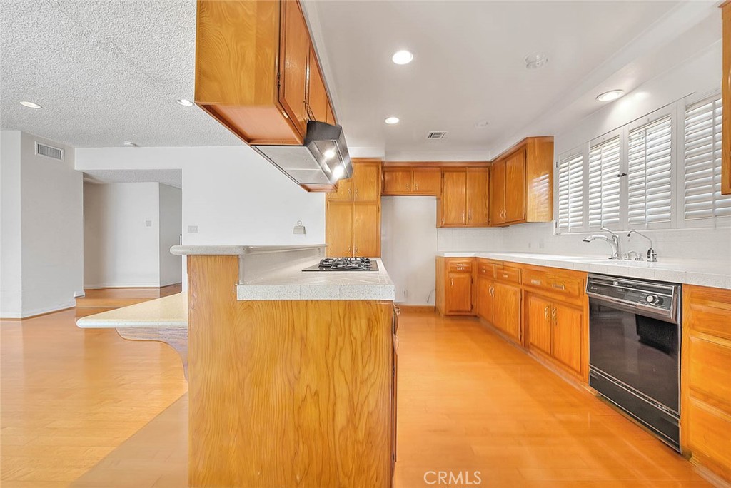 620 North 5th Street Montebello, CA 90640 - Photo 20 of 68 a large kitchen with stainless steel appliances a large counter top a stove a chimney a sink and a large window