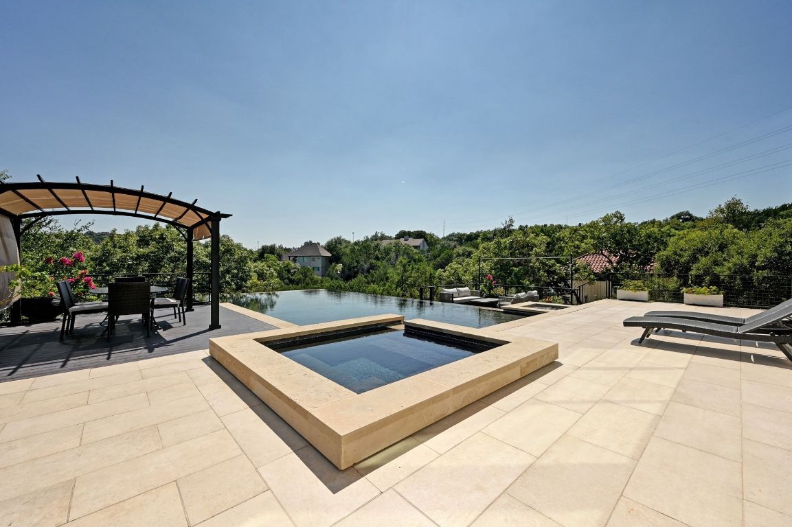 405 Barrett Lane, Unit 1 Austin, TX 78733 - Photo 11 of 26 a view of a swimming pool with a lounge chair