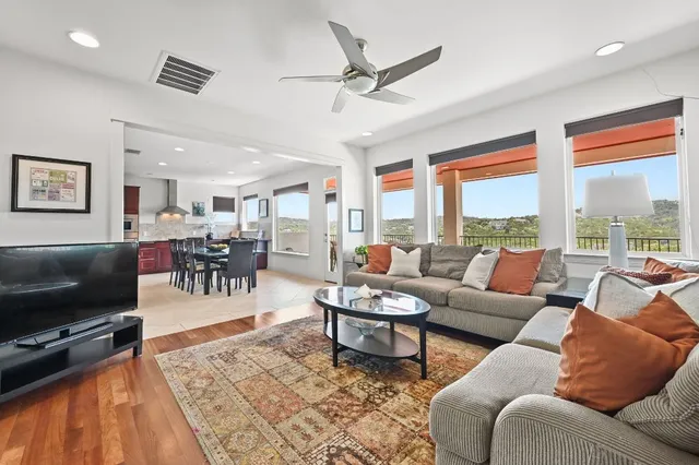 a living room with furniture a flat screen tv and a floor to ceiling window