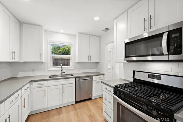 a kitchen with stainless steel appliances a sink dishwasher stove microwave and cabinets