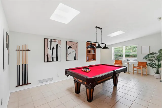 a dining room with stainless steel appliances kitchen island granite countertop a dining table chairs and a refrigerator