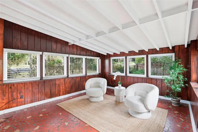 a dining room with furniture and large windows