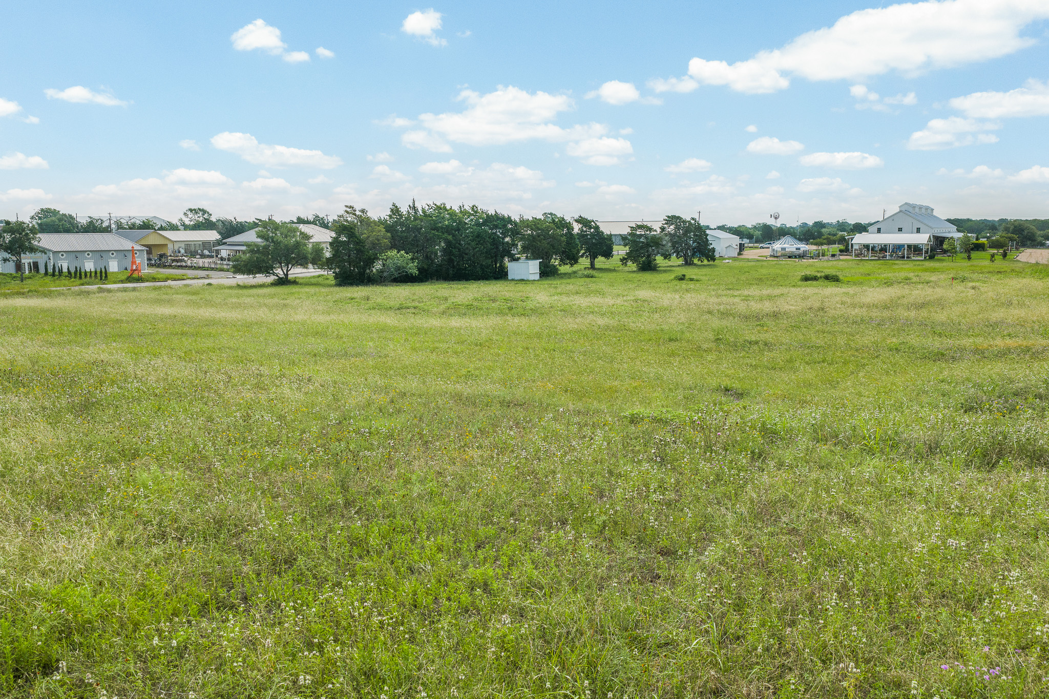 109 Compound Lane Round Top, TX 78954 - Photo 7 of 23 Cultivate your vision on this expansive green lot with clear skies, offering ample space for development.