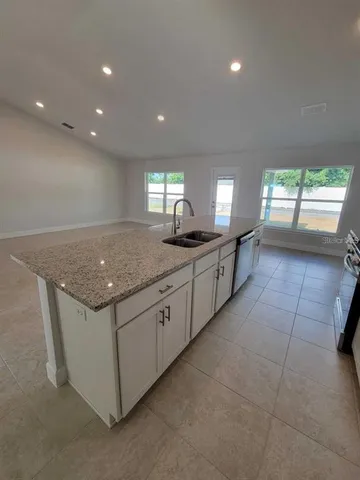 a kitchen with granite countertop sink and cabinets