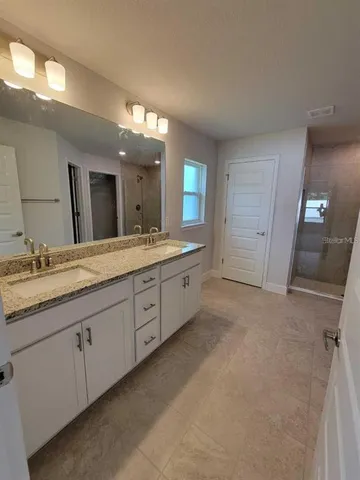 a spacious bathroom with a granite countertop sink mirror and double