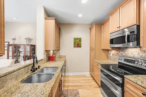 a kitchen with stainless steel appliances granite countertop a sink and a microwave