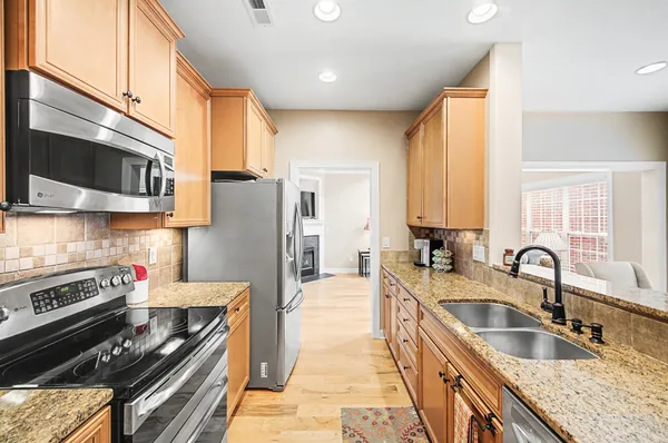 a kitchen with stainless steel appliances granite countertop a sink stove and refrigerator