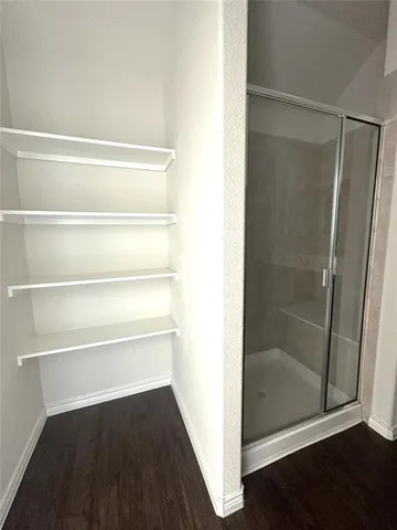 a view of walk in closet with wooden floor