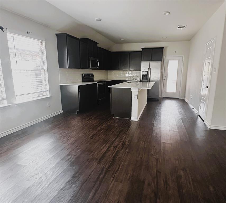 223 Garden Grove Drive Waxahachie, TX 75165 - Photo 3 of 24 a kitchen with wooden floors and wooden cabinets