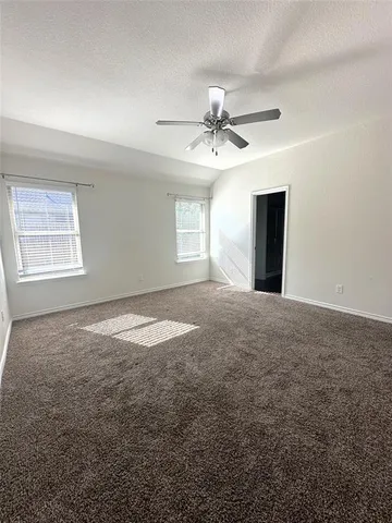 a view of a big room with windows and chandelier fan
