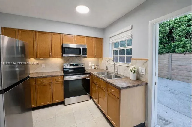 a kitchen with granite countertop a sink stove and cabinets