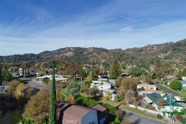 an aerial view of a city with lots of residential buildings lake and mountain view in back