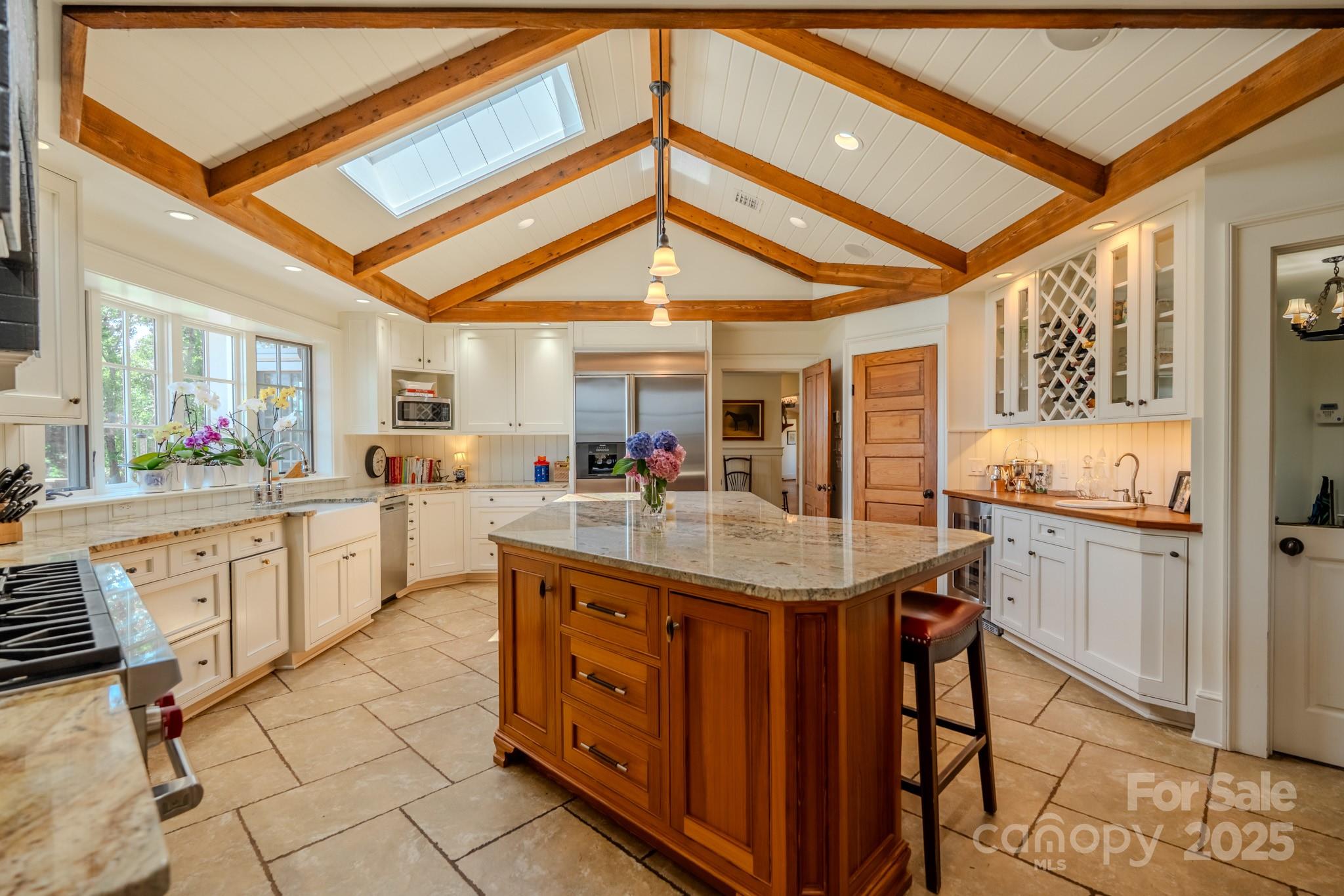 650 Golf Course Road Tryon, NC 28782 - Photo 20 of 48 a kitchen with stainless steel appliances kitchen island granite countertop a table chairs in it and a microwave
