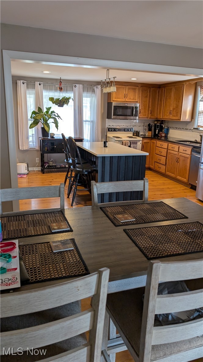 10951 Stump Road Minerva, OH 44657 - Photo 13 of 16 Kitchen featuring a wealth of natural light, stainless steel microwave, a kitchen island, and electric range