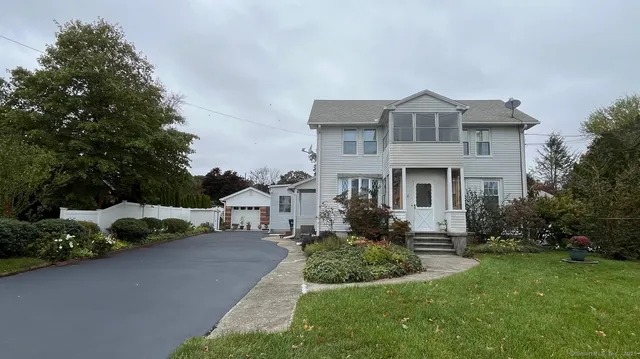 a front view of a house with a yard and potted plants