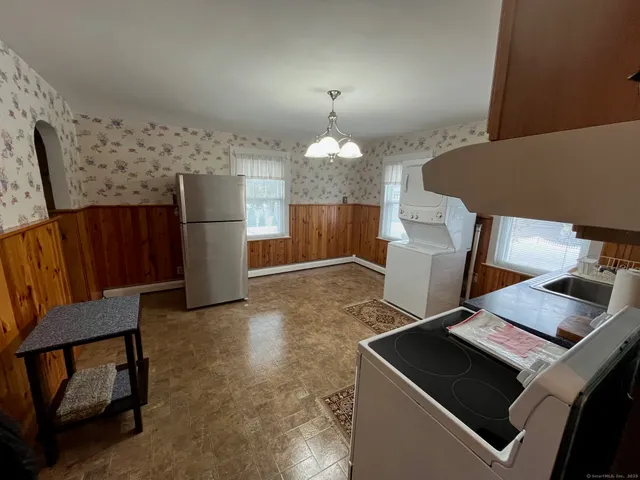 a kitchen with stainless steel appliances a stove top oven a sink dishwasher a refrigerator and white cabinets