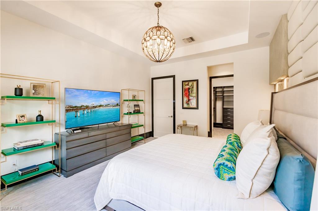 9214 Mercato Way Naples, FL 34108 - Photo 18 of 41 a bedroom with a bed and a chandelier