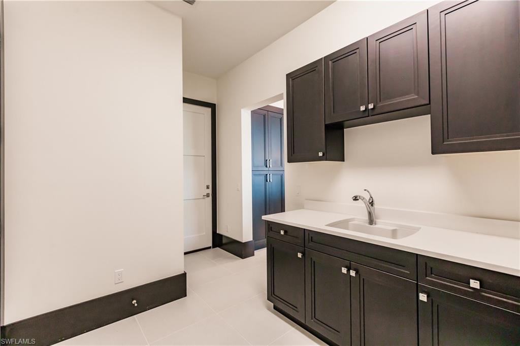 9214 Mercato Way Naples, FL 34108 - Photo 25 of 41 a kitchen with a sink and cabinets