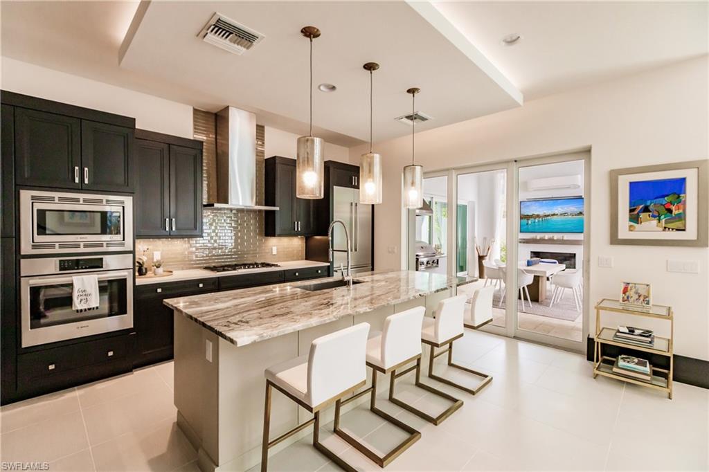 9214 Mercato Way Naples, FL 34108 - Photo 9 of 41 a kitchen with a stove a refrigerator and a stove top oven
